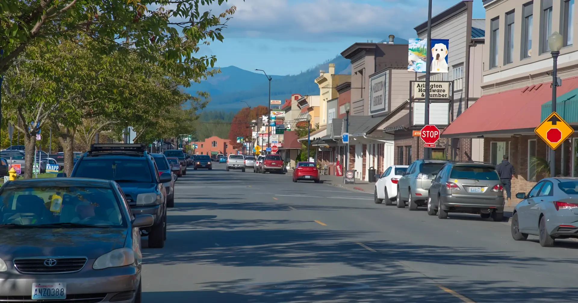 A view of the bustling Olympic Ave in Arlington WA, featuring historic buildings and mountain views, curated by a Real Estate Expert in Arlington WA.